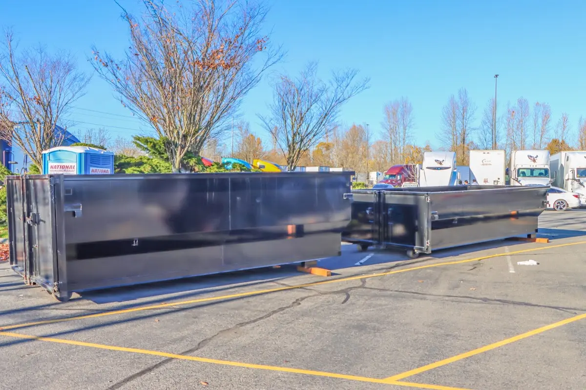 Professional dumpster rental service with roll-off container on residential driveway in New Britain